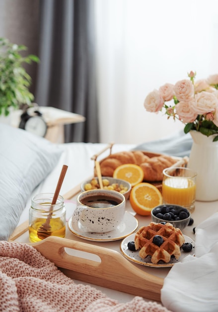 Desayuno romántico con croissants de café y rosas