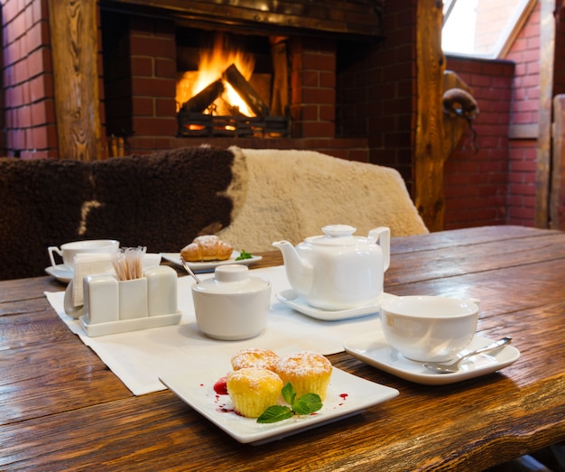 Desayuno romántico para dos personas cerca de la chimenea.