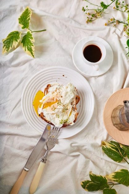 Desayuno en sábanas blancas buenos días tostadas con huevos escalfados café