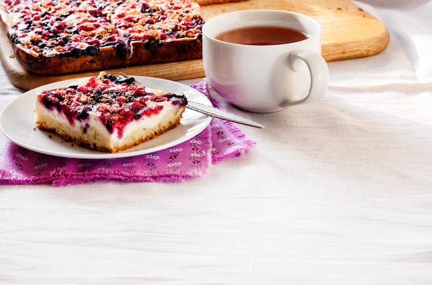 Desayuno sabroso Delicioso pastel con bayas y requesón y una taza de té