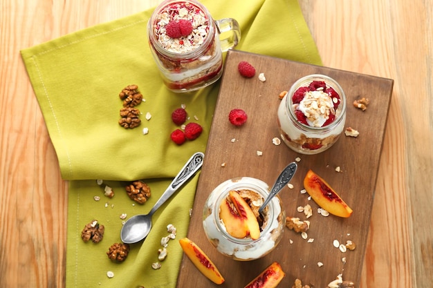 Desayuno saludable con avena y yogur en frascos en la mesa