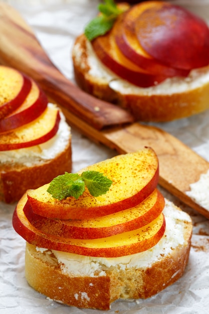 Desayuno saludable. Bruschetta con durazno, nectarina, requesón, canela y menta