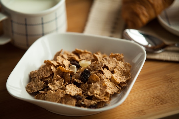 Desayuno saludable en la cama con café y croissant, copos de maíz con leche. Servicio de hotel.