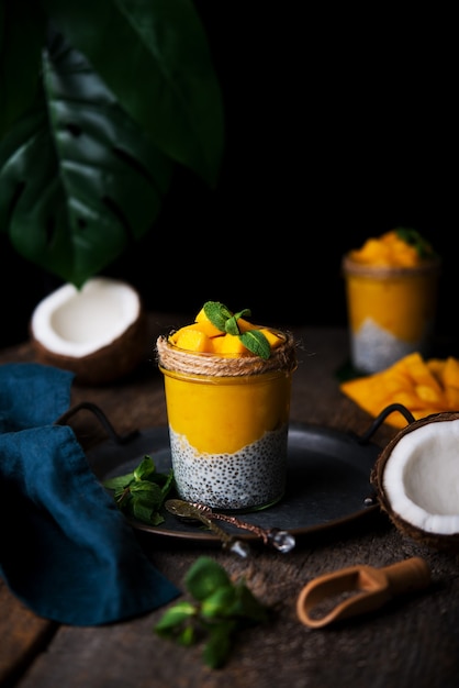 Desayuno saludable casero, pudín de chía con leche de coco y mango en una mesa de madera