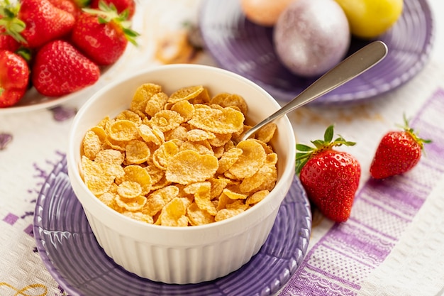 Desayuno saludable copos de maíz y fresas con leche y huevos duros