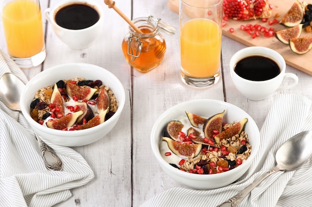Desayuno saludable y delicioso. Muesli de avena con yogur griego, higos frescos, frutos secos y granada.