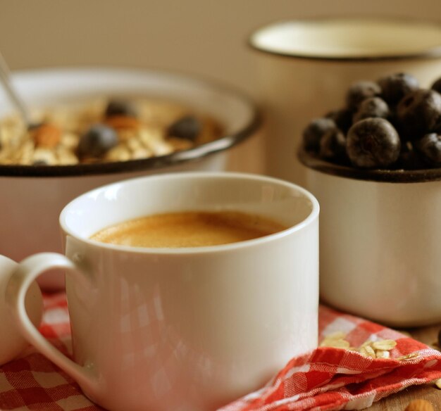 Un desayuno saludable es un gran comienzo para un nuevo día Gachas de avena, café, bayas y nueces en una mesa de madera