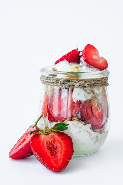 Desayuno saludable granola de avena con yogur griego y nueces muesli de fresa en frascos con luz