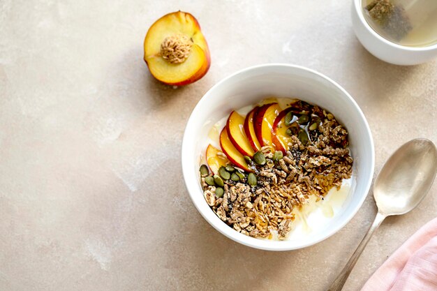 Desayuno saludable Granola con frutos secos de melocotón, semillas de chía, semillas de calabaza y leche en un bol