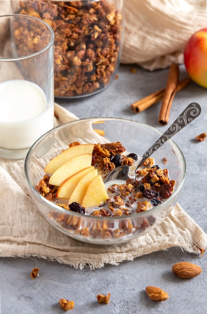 Desayuno saludable de granola con manzanas y canela en una mesa gris