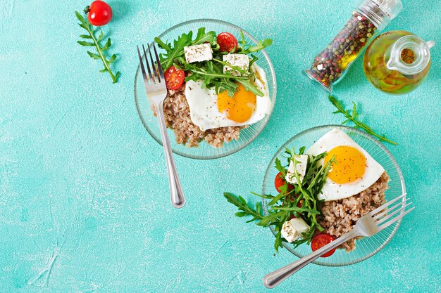 Desayuno saludable con huevo, queso feta, rúcula, tomate y gachas de alforfón
