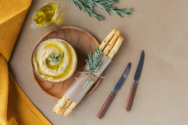 Desayuno saludable con hummus casero, romero y pan tostado. Dieta y bocadillos saludables.