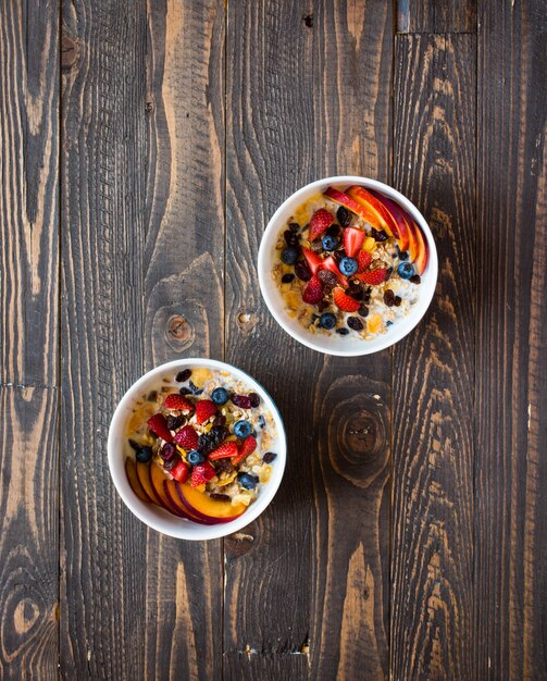 Desayuno saludable con milkmuesli y fruta sobre un fondo de madera.