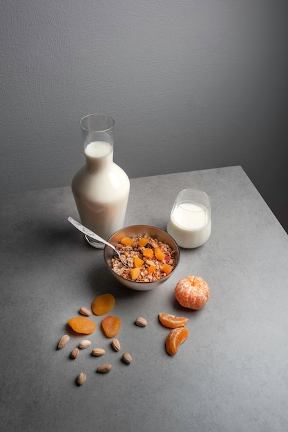 Desayuno saludable de muesli con fruta fresca y yogur en una mesa gris