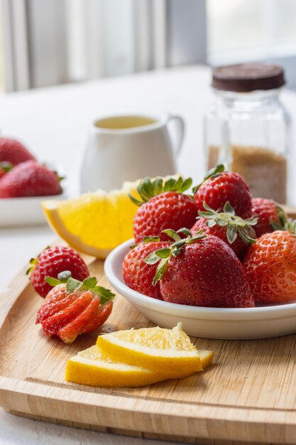 Un desayuno saludable de naranjas y fresas Una mesa de madera sobre un fondo con naranjas en rodajas