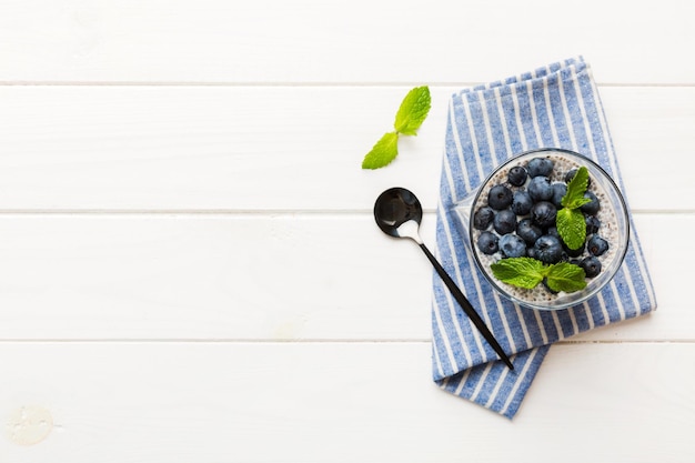 Desayuno saludable o mañana con pudín de vainilla con semillas de chía y bayas de arándanos en el fondo de la mesa Dieta de comida vegetariana y concepto de salud Pudín de chía con leche de coco y arándanos