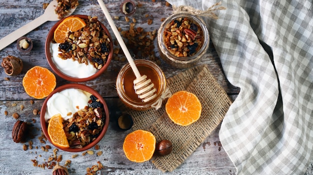 Desayuno saludable o postre. Yogurt con granola y mandarina. Granola casera. Miel. Endecha plana.