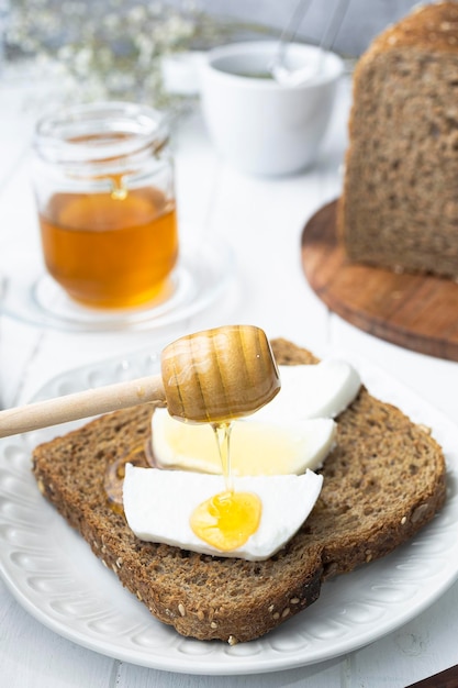 Desayuno saludable con pan integral queso fresco de cabra y miel cruda Un delicioso desayuno