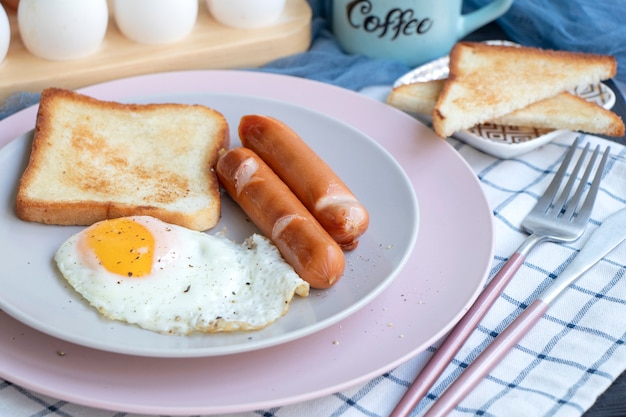 Un desayuno saludable para una persona Concepto de cocina de desayuno Tostadas de huevo frito y salchichas