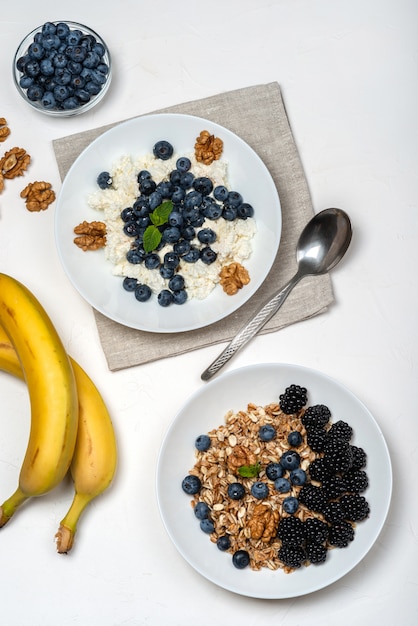 Desayuno saludable. Requesón con arándanos, nueces, miel y menta en un tazón blanco Vista superior.