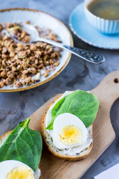 Foto desayuno saludable y saludable: muesli, sándwich con huevo, café, naranja y jugo