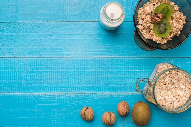 Desayuno saludable con tazón de avena casera con frutas y leche sobre fondo de madera rústica. Naturaleza muerta. Copia espacio