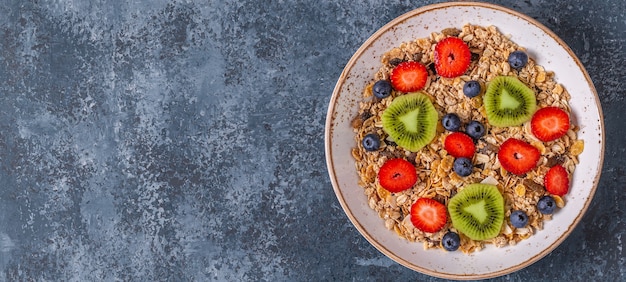 Desayuno saludable, tazón con granola de avena y bayas, vista superior.