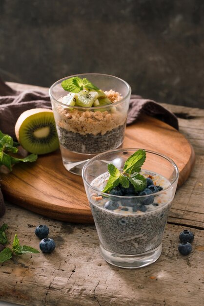 Desayuno saludable - tazón de muesli, bayas y frutas, nueces, kiwi, leche