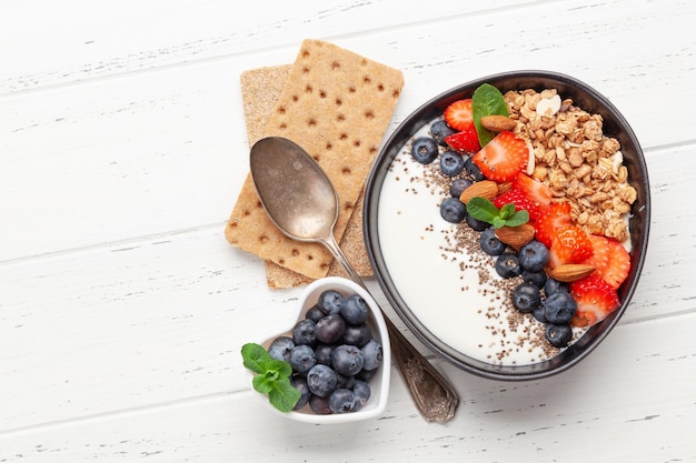 Desayuno saludable con tazón de yogur de granola y bayas frescas