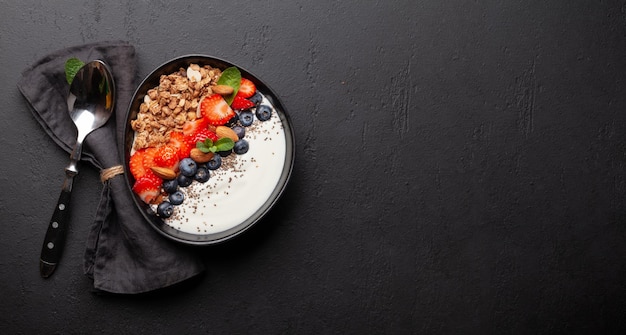 Desayuno saludable con tazón de yogur de granola y bayas frescas