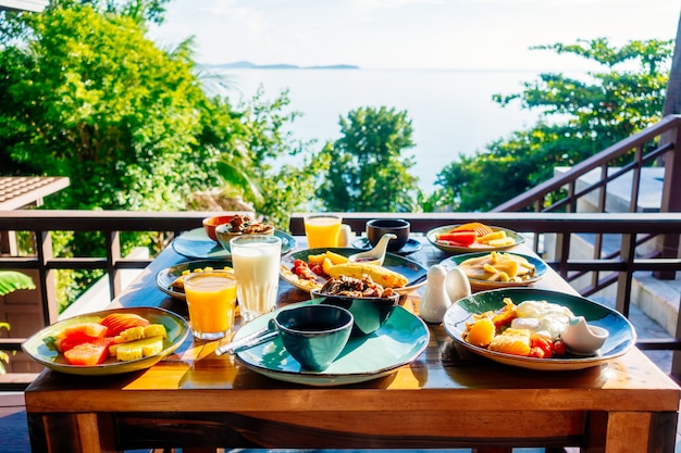 Desayuno saludable con tocino de huevo panqueques jugo de naranja pan de leche y café