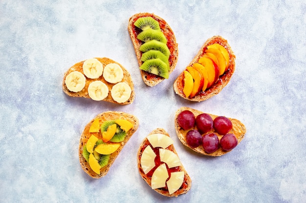 Desayuno saludable tostadas con mantequilla de maní, mermelada de fresa, frutas