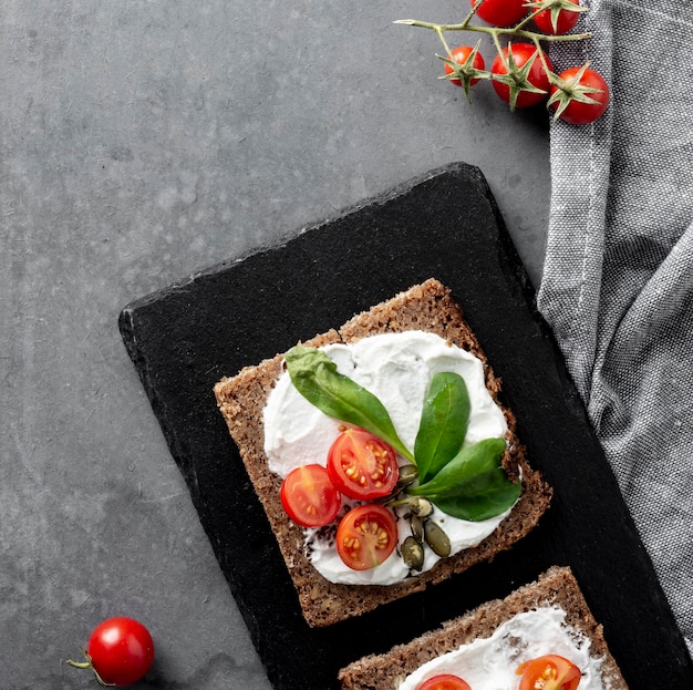 Desayuno saludable con tostadas y tomates en tabla de cortar