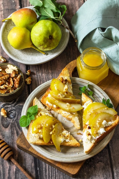 Desayuno saludable de verano Tostadas a la parrilla con nueces de miel de pera caramelizadas y queso ricotta