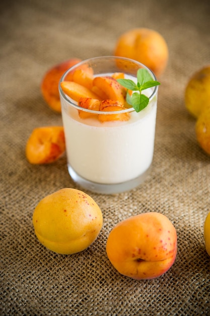 Desayuno saludable de yogur casero en un vaso con albaricoques frescos