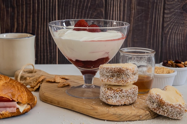 Desayuno saludable de yogur natural y galletas de bayas y croissant servido