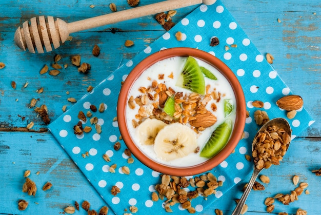 Desayuno saludable: yogurt con granola, plátano y kiwi