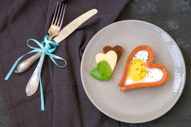 Foto el desayuno de san valentín consiste en huevos revueltos con pan en forma de corazón.