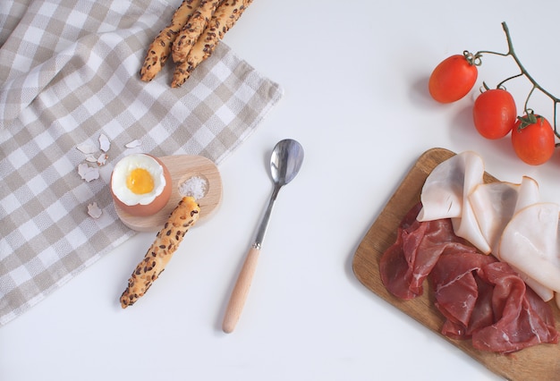 Desayuno servido huevo cocido en huevera de madera