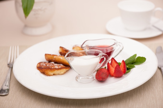 Desayuno servido con tostadas con fresas y leche.