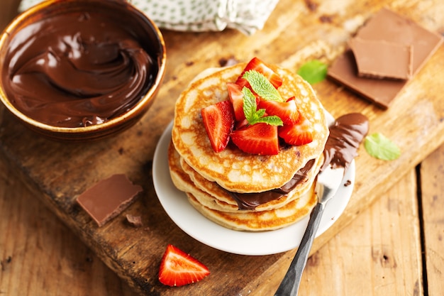 Para el desayuno se sirven deliciosos panqueques recién hechos y decorados con pasta de fresa y chocolate. De cerca