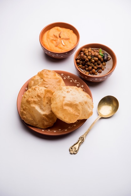 Desayuno Suji o Sooji Halwa Puri o Sheera o Shira Poori, servido en plato y tazón. enfoque selectivo