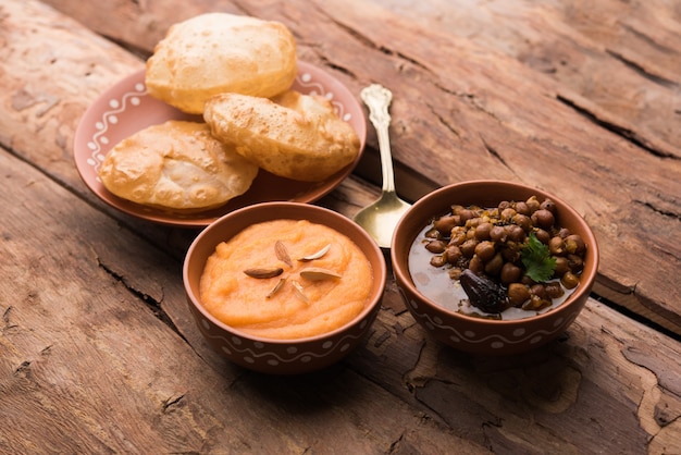 Desayuno Suji o Sooji Halwa Puri o Sheera o Shira Poori, servido en plato y tazón. enfoque selectivo