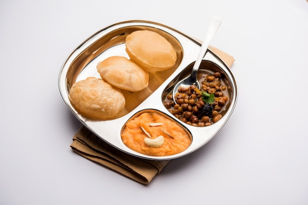 Desayuno Suji o Sooji Halwa Puri o Sheera o Shira Poori, servido en plato y tazón. enfoque selectivo