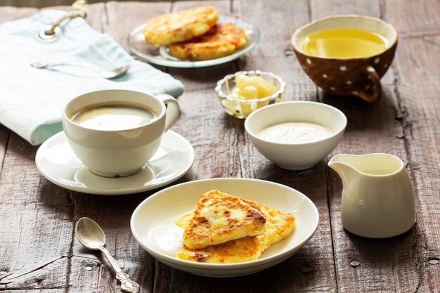 Desayuno de tartas de queso, café y té. Tartas de queso de forma triangular inusual.