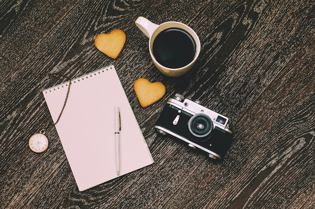 Foto desayuno con una taza de café y una galleta en el trabajo en el piso