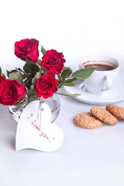 desayuno con taza de café y rosas rojas