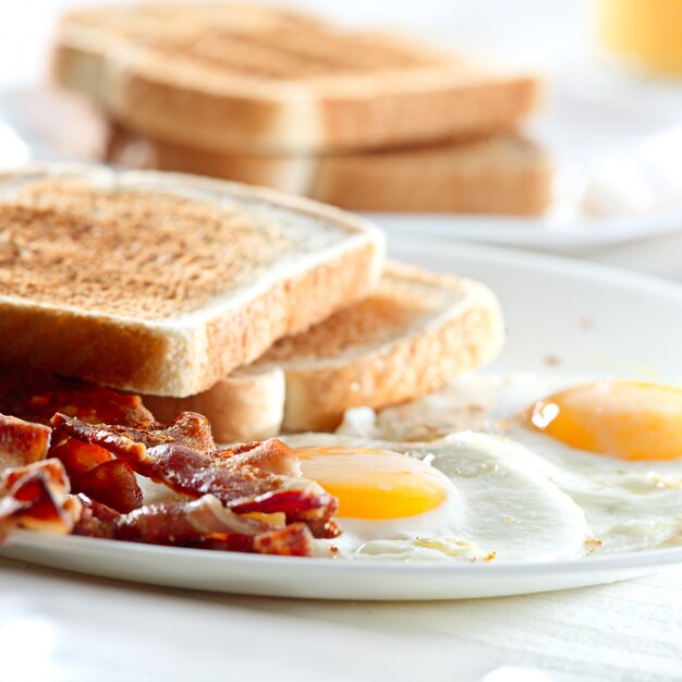 Desayuno con tocino, huevos y tostadas