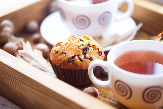 Desayuno - torta y taza de té en una bandeja de madera