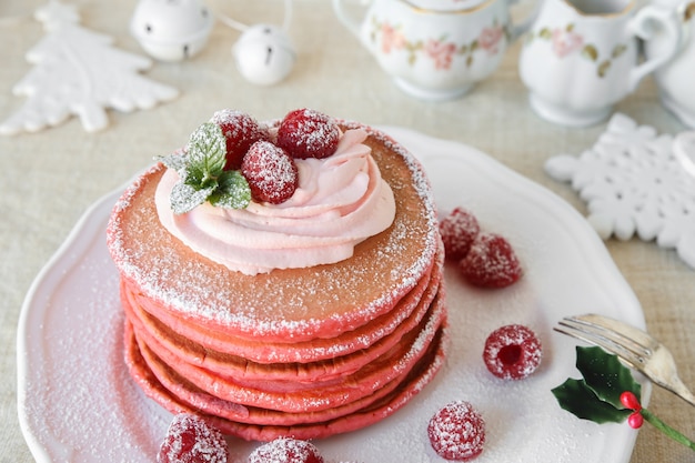 Desayuno de tortitas de terciopelo rojo con decoración navideña.